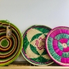 Large grass-woven shallow trays with green rim detail